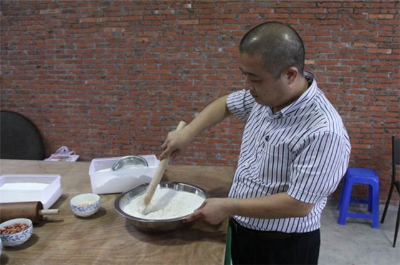 陈淦忠展示传统小食—云片糕生产中的“调粉”技艺